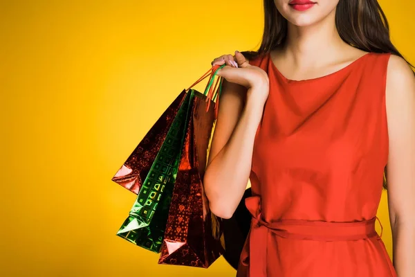 A young girl in a red dress loves shopping, bought a lot of gifts — Stock Photo, Image