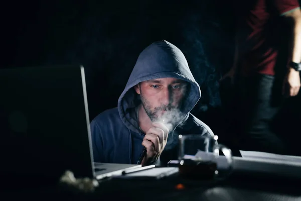 Mysteriöser bärtiger Mann Hacker, der im Dunkeln eine Wasserpfeife raucht und Laptop hackt — Stockfoto