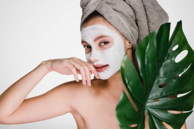 genç kız Spa yordamlar, havlu kafa, yüz maskesi nemlendirici şişkin üzerinde yapıyor