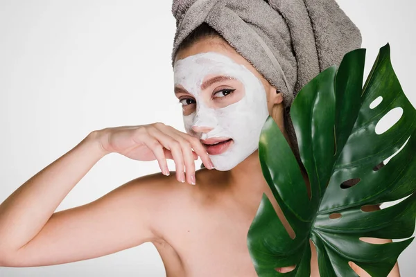 Jeune fille faisant des procédures de spa, sur la tête de serviette, sur le visage gonflant masque hydratant — Photo