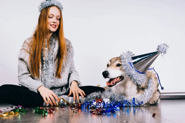 Kızıl saçlı kız gülümseyerek onu köpek, Noel atmosferi, Noel için bekleyen ile katta oturur — Stok fotoğraf