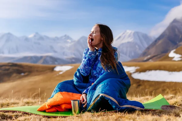 Junges Mädchen gähnt im Hintergrund der kaukasischen Berge, reist — Stockfoto