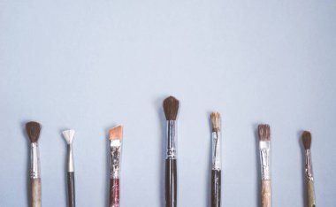 mavi bir masada sanatsal fırçaların farklı boyutlarda vardır