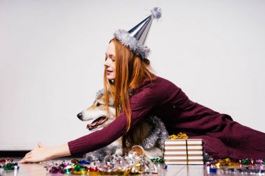 Yeni yıl, tinsel bir sürü köpeğini sarılma şirin Kızıl saçlı kız