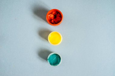 mavi bir masada kavanoz ile renkli bir guaş vardır