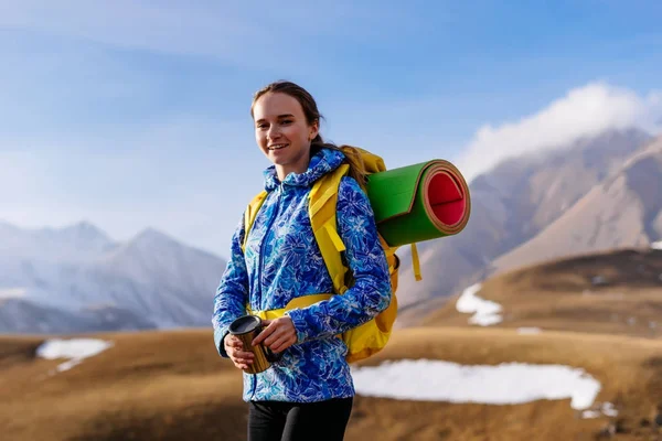 Szczęśliwa młoda dziewczyna w Błękitnej Kurtki przemieszcza się wzdłuż grzbietu Kaukaska z plecakiem — Zdjęcie stockowe