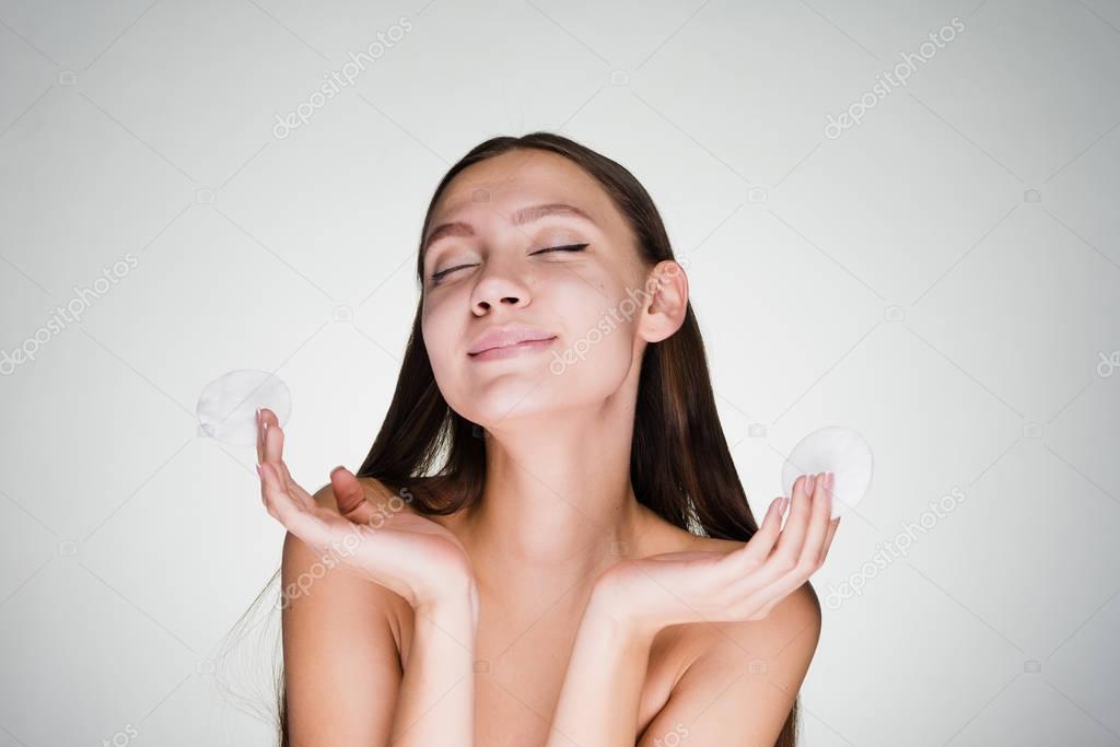 young attractive girl holding a cotton wool for cleansing the skin of the face