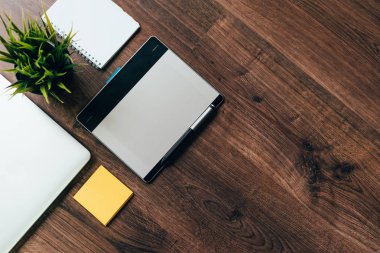 ahşap bir masa üzerinde bir laptop ve bir defter olduğunu