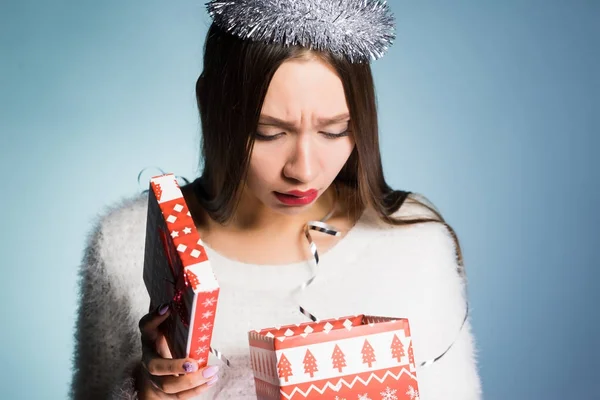 Молода дівчина у святковому капелюсі розчарована своїм подарунком — стокове фото
