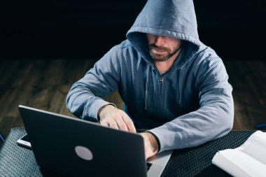 Bir hacker bir kazak bir kukuleta ile ' bir dizüstü oturur
