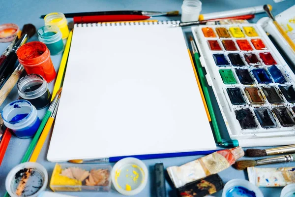 Белый лист бумаги на фоне разноцветных красок — стоковое фото