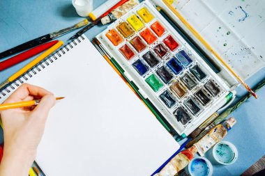 bir fırça ve boya ile bir beyaz kağıt üzerinde kadın çizer