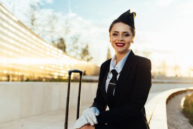 mutlu hostes kız mavi gökyüzü arka plan üzerinde çanta