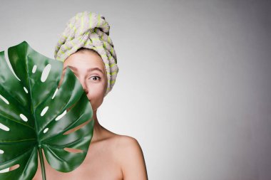 holding bir yaprak yeşil, gün spa ve güzellik kafasına, bir havlu ile güzel kız gülerek