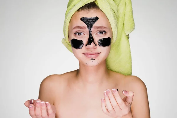 Niña con una toalla en la cabeza se aplicó una máscara en las áreas problemáticas de la piel — Foto de Stock