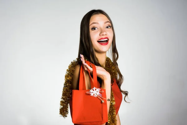 Happy smiling girl with red lipstick received an expensive fashionable bag for the new year — Stock Photo, Image