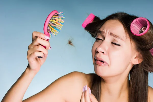 Jovem triste quer fazer um corte de cabelo, perde o cabelo, mantém um pente — Fotografia de Stock