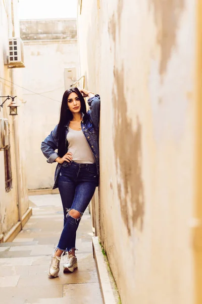 Stylish black-haired girl posing against the colorful architecture of the city of Baku in Azerbaijan — Stock Photo, Image