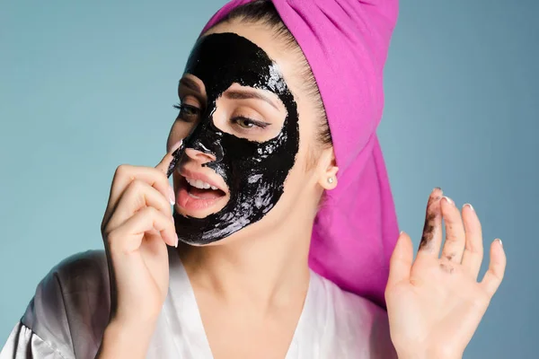 Dziewczyna z różowy ręcznik na głowie nosi czarna maska na twarzy — Zdjęcie stockowe