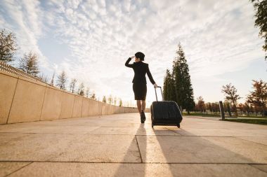 ince genç kadın hostes bir çanta ile uçuş devam ediyor