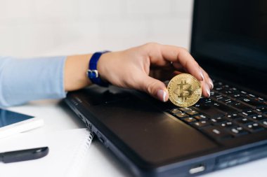 genç kız bitcoin tutan dizüstü bilgisayarda çalışma