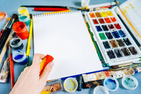 Hoja blanca de papel sobre un fondo de pinturas multicolores —  Fotos de Stock