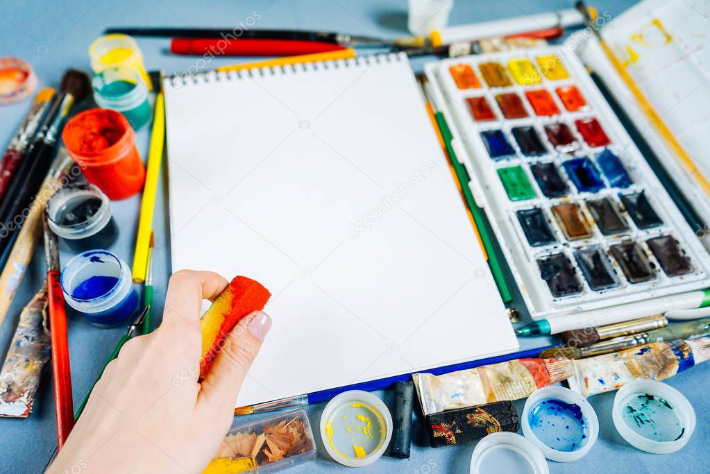 white sheet of paper on a background of multi-colored paints