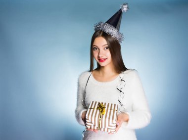 Genç kız bir Noel hediyesi ile beyaz bir arka plan üzerinde duruyor