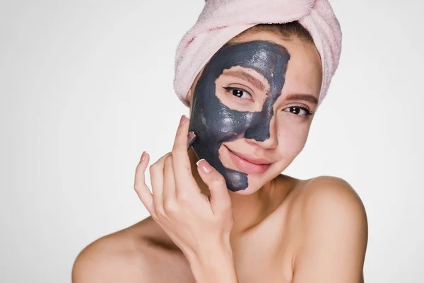 Счастливая девушка надевает очищающую маску на лицо — стоковое фото