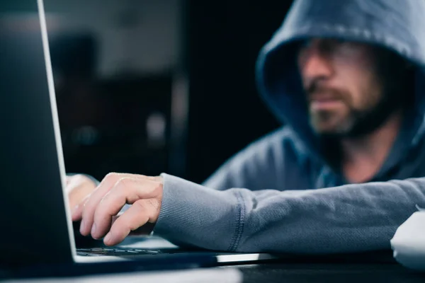 Junge Hacker arbeiten zu Hause hinter Laptop — Stockfoto