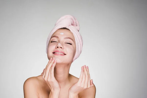 Young girl on white background puts on face mask — Stock Photo, Image