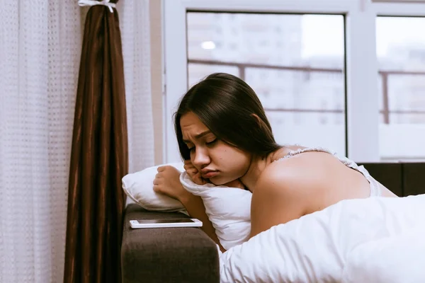 Молодая разочарованная девушка лежит в постели с простудой — стоковое фото