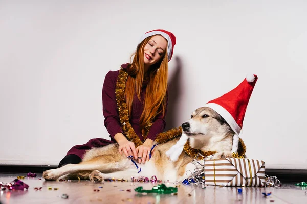 穿着新年西服的快乐女孩坐在狗旁边 — 图库照片