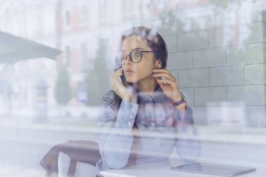 Gözlüklü genç kız telefonda konuşuyor