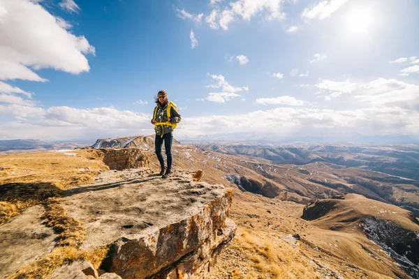 Junges Mädchen steht auf dem Hintergrund einer Berglandschaft — Stockfoto