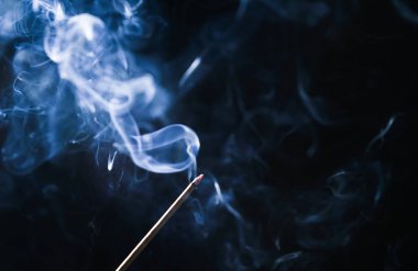 Karanlık bir odada küçük bir mum ile tütsü yaktım