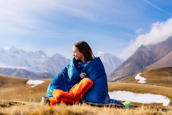 Молодая девушка в спальном мешке на фоне гор — стоковое фото