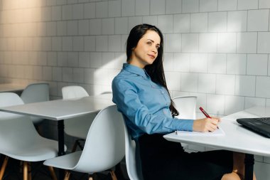 sevimli genç esmer kız mavi gömlekli ikindilerde pencereden dışarı bakarak