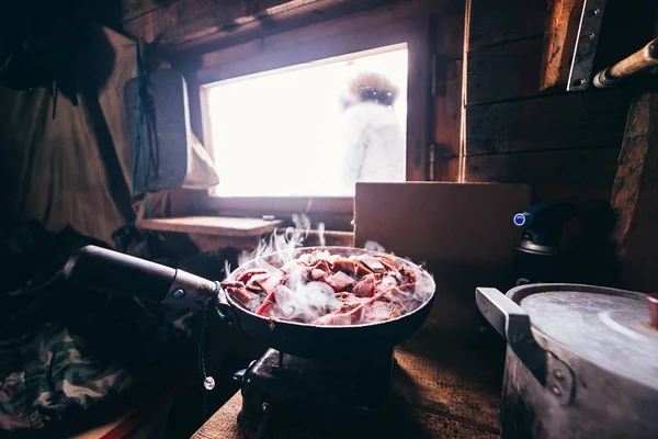 in a hunting lodge in a frying pan the deer meat is roasted