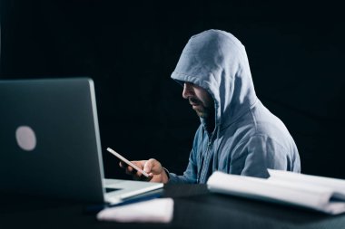 gizemli sakallı adam yüzünü başlık altında gizler, telefonda şifre kesmek
