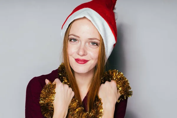 Щасливі дівчини з рудим волоссям у червоній кепці як Санта Клаус посміхається — стокове фото
