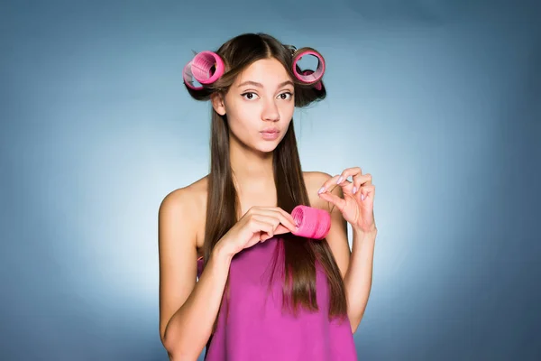 Bonito jovem quer um penteado elegante, sobre os encrespadores de cabeça — Fotografia de Stock