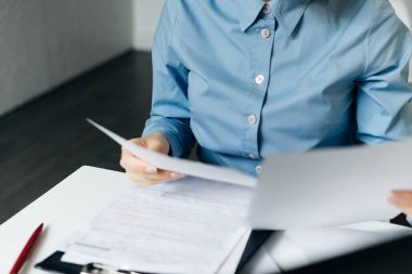iş kadını mavi gömlekli önemli belgeleri inceler