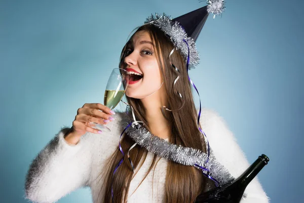 Счастливая девушка в кепке празднует Новый год, пьет шампанское — стоковое фото