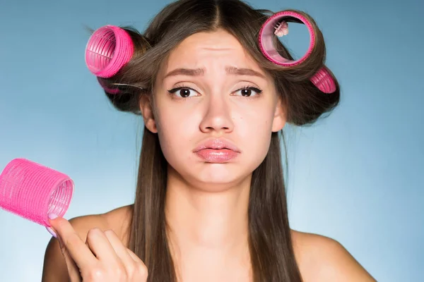 Triste joven chica no puede hacer su pelo con rulos —  Fotos de Stock
