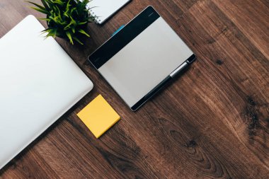 Tasarımcı ahşap masada bir dizüstü bilgisayar ve bir dizüstü bilgisayar var