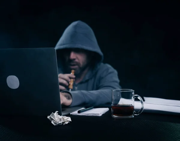 Junger Kerl Hacker sitzt am Laptop Tee trinken und eine Wasserpfeife rauchen — Stockfoto