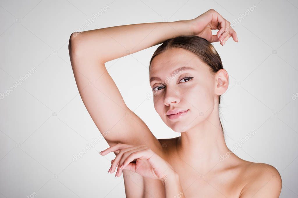 a young girl after a shower is shaking on her armpits