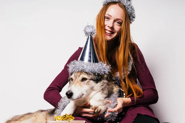 Heureuse fille aux cheveux roux étreignant son chien, attendant le nouvel an et Noël — Photo