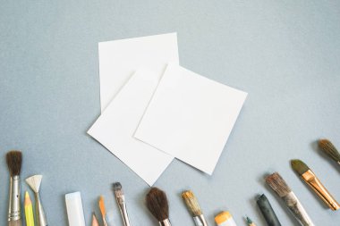 bir mavi beyaz bir kağıt ve bir sürü Sanat fırçalar ve kalem tablodur